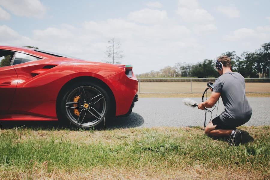 man recording audio of a ferarri car