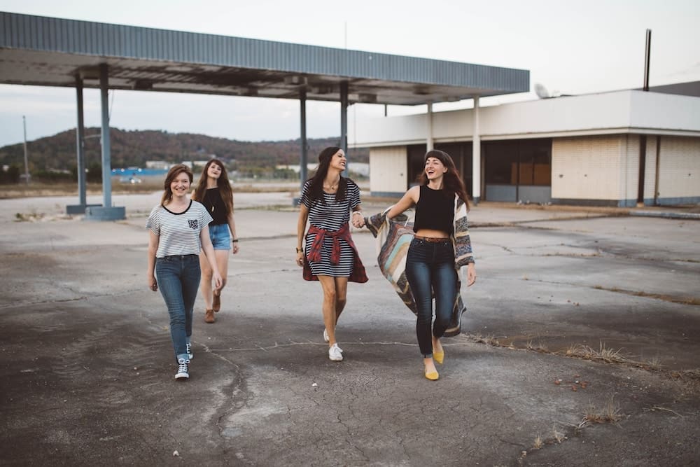 Four girl friends walking together and laughing