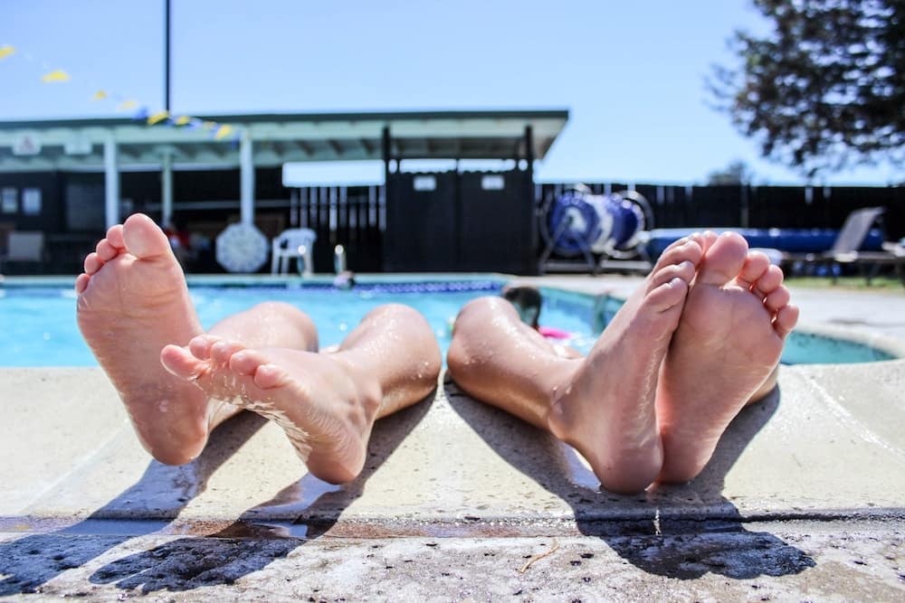 Two friends hanging out at the pool during a hot summer day