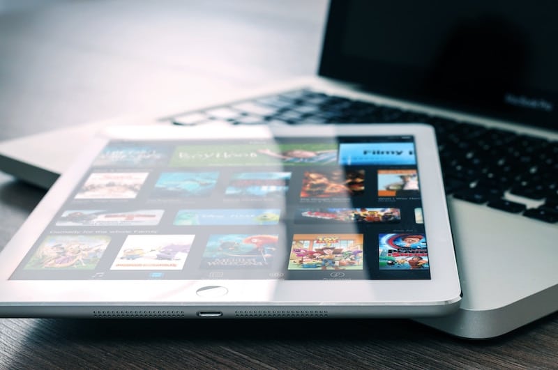 White iPad Laying on top of a macbook pro