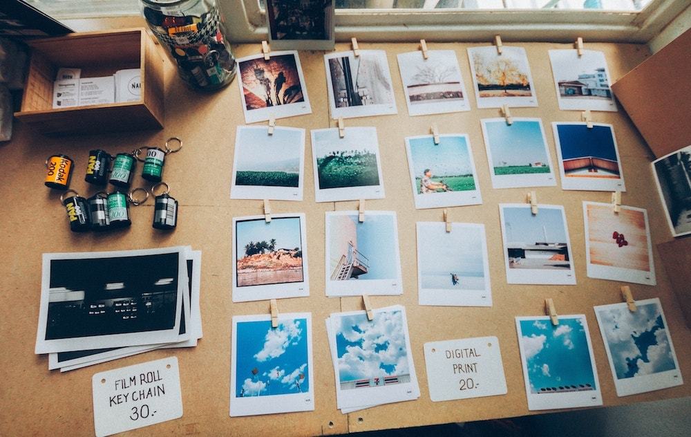 Printed polaroid pictures neatly organized on a wooden desk