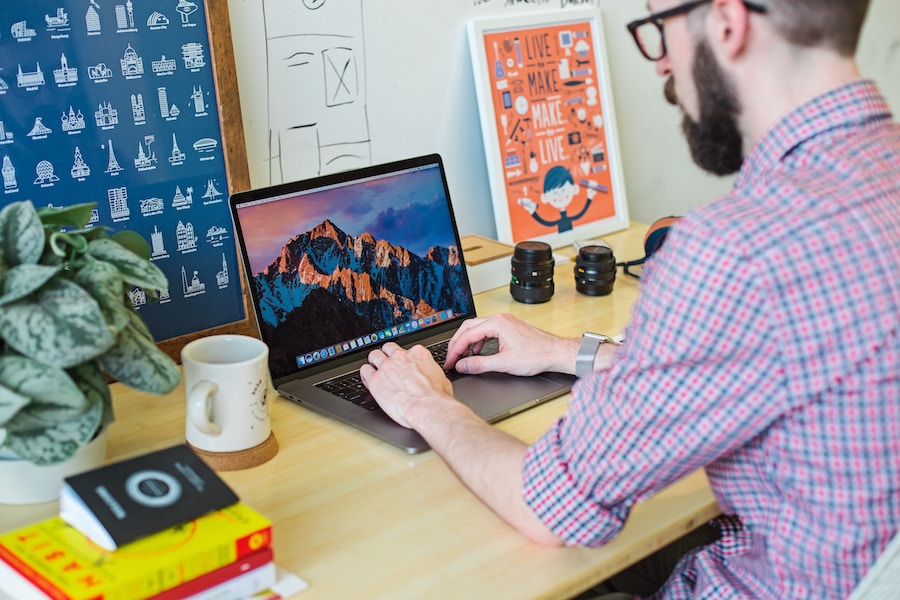 Young Hipster Man using a Macbook Pro