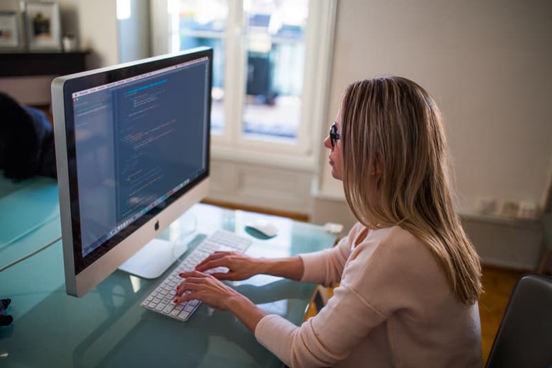 Woman typing on iMac inside her home office