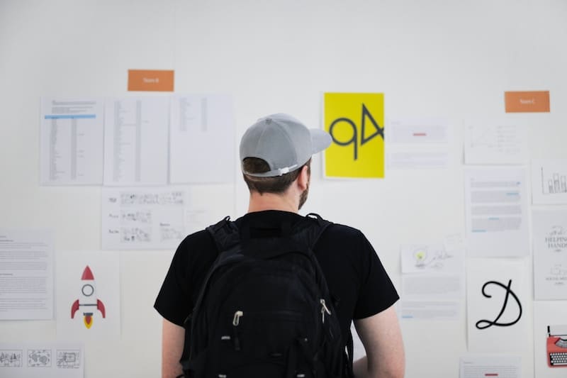 young mad staring at a whiteboard inside a startup office