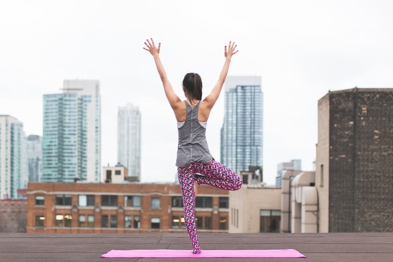 girl doing yoga on the rooftop of a skyscraper in new york city