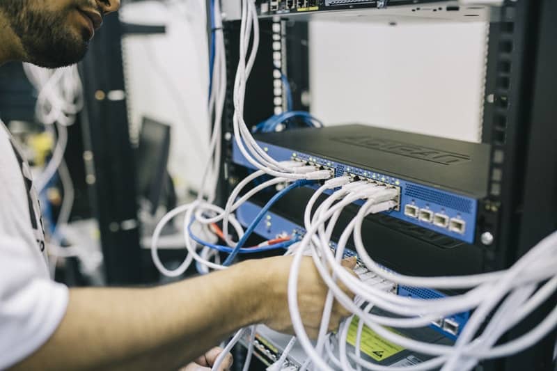 Man connecting ethernet cables to a server
