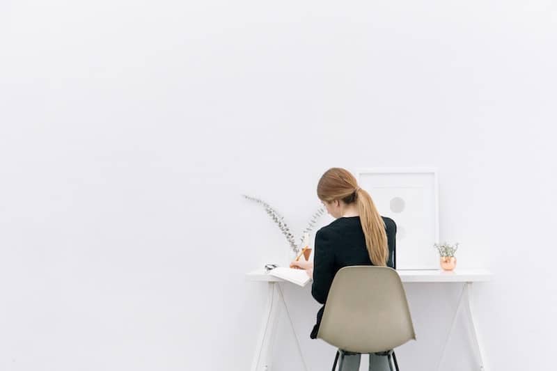 Young woman working behind a minimal desk