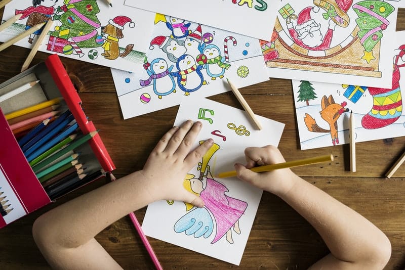 top-angle-photo-of-child-holding-pencil-while-drawing-female-angel-playing-wind-instrument