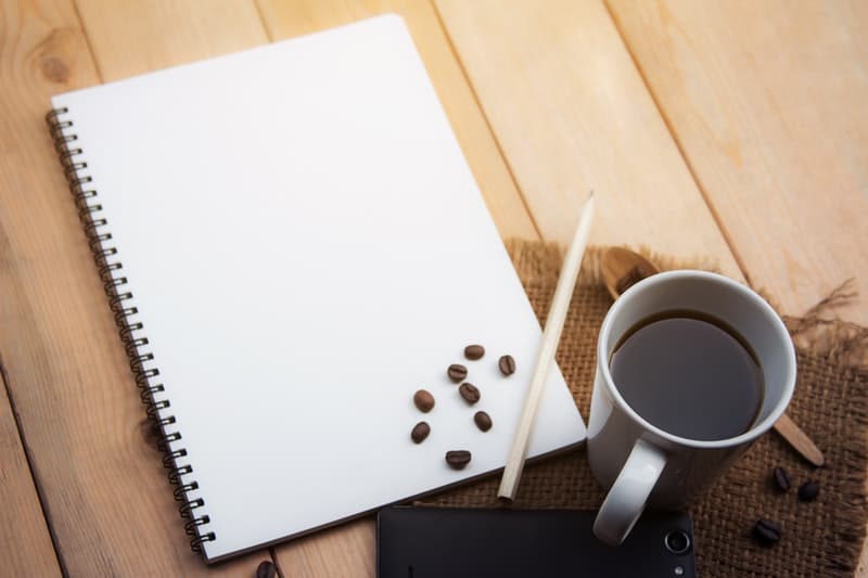 black coffee and a notepad laying on top of the breakfast table