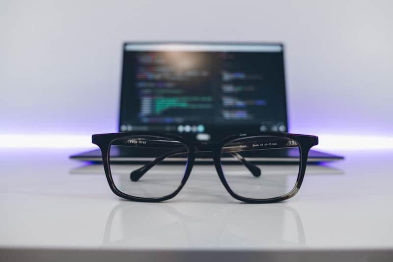 Glasses laying in front of an apple macbook pro