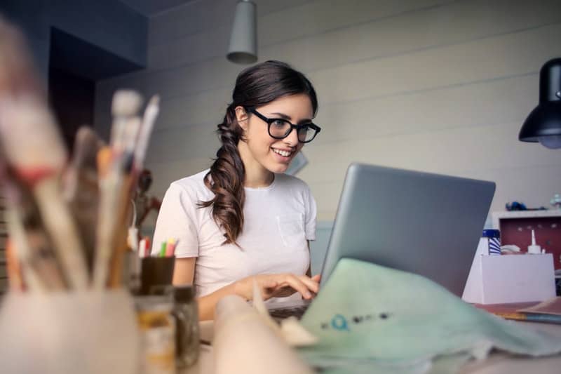 Young woman using her laptop to research