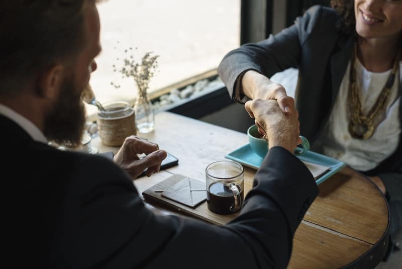 man and woman shaking hands after a meeting