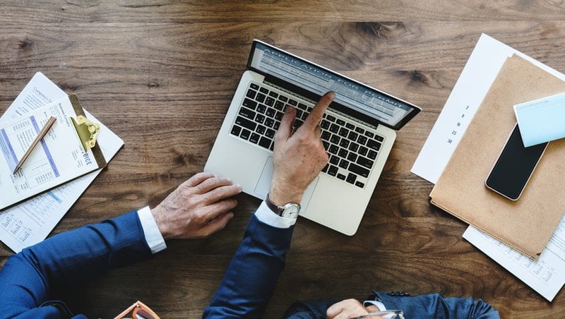 two business men evaluating a writing service on their laptop