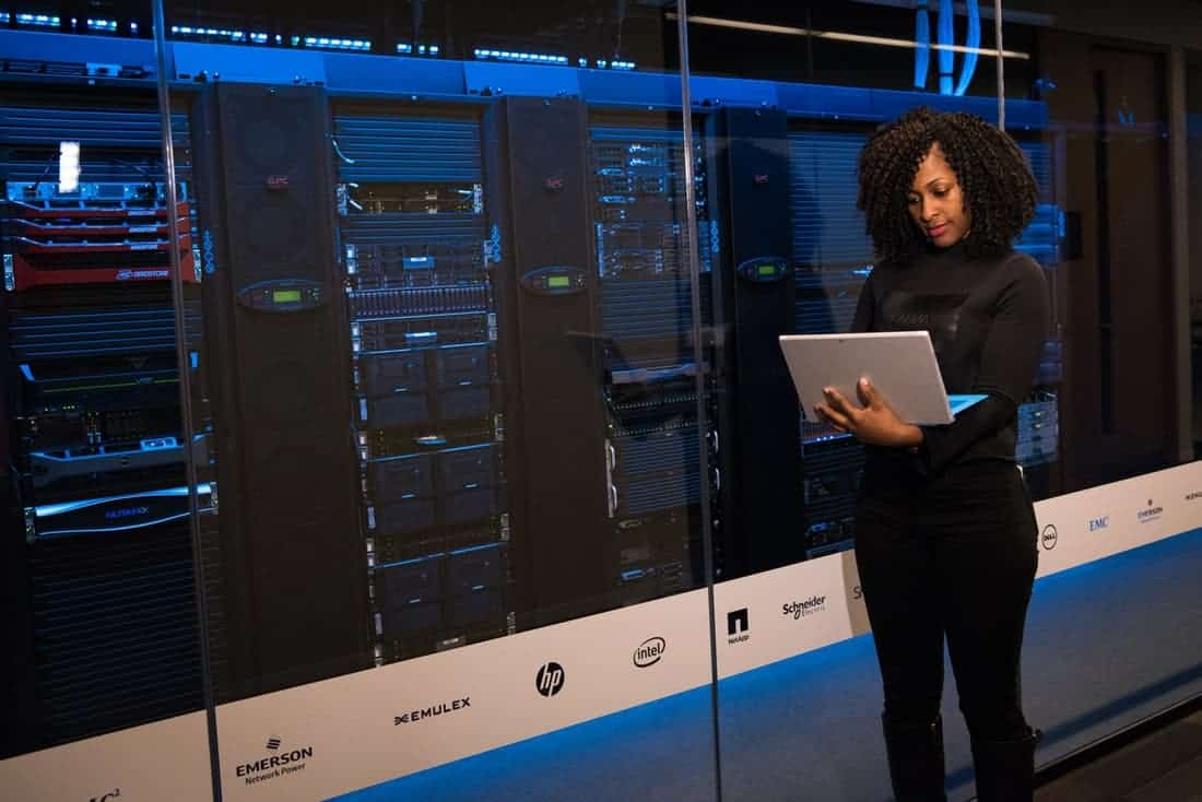 woman standing inside a large server room-min