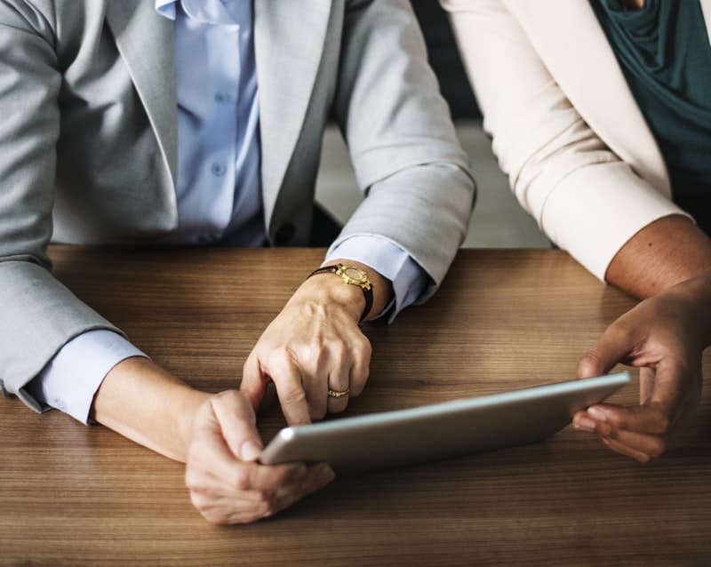 Two people going over their businees plan on a mobile tablet