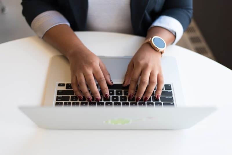 adult typing on her laptop