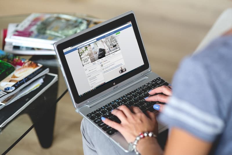 woman using a notebook to update her business facebook page