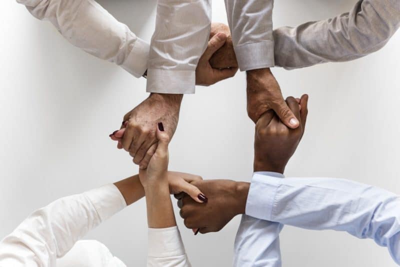 Four office people uniting hands