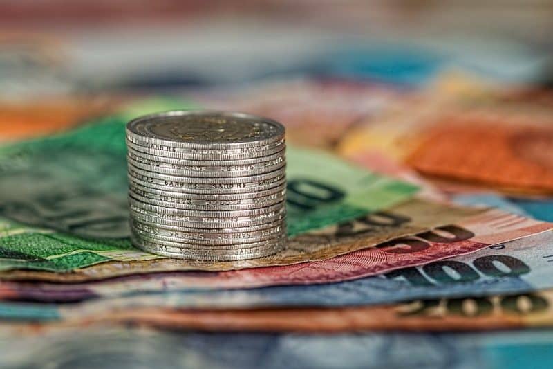 stack of coins on top of currency bills