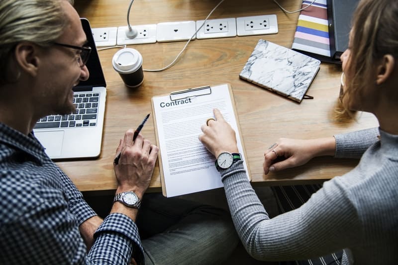 two coworkers looking over a business contract