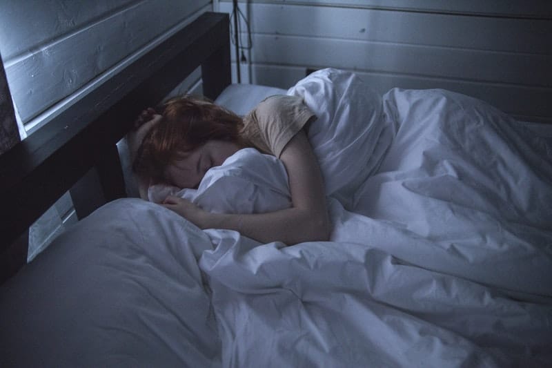 woman sleeping in a dark blue room
