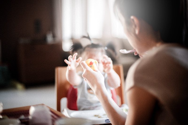 Asian mother feeding her child for lunch