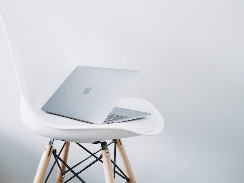 Silver Macbook Pro Sitting on a White Chair
