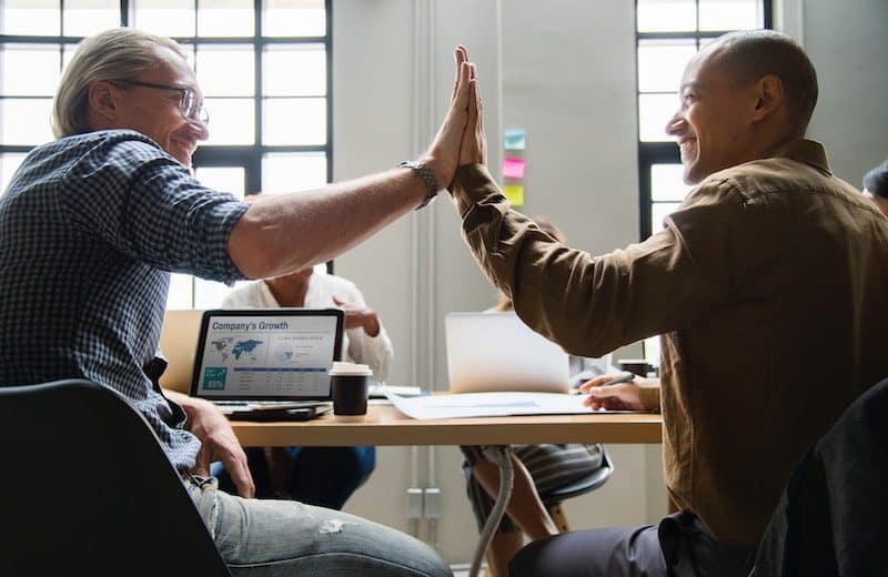 Two employees giving each other a high five