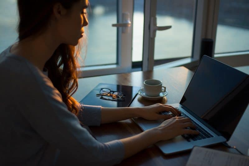 Woman Typing on Her laptop During Dusk