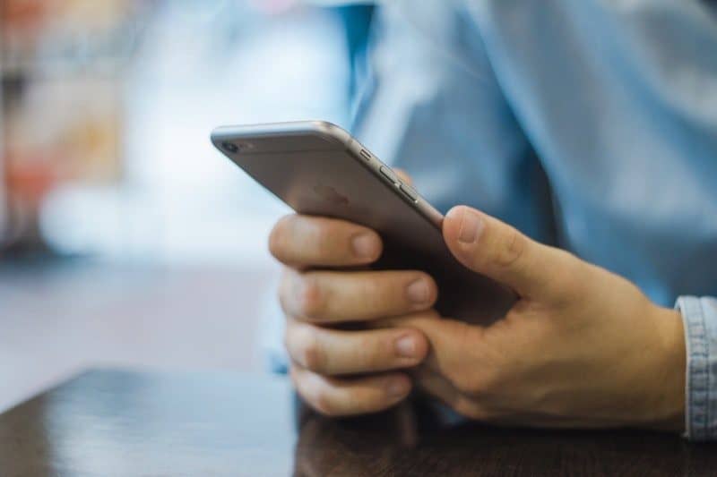 man checking his iphone for new emails