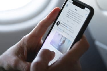Man Checking his Twitter News Feed on The Plane