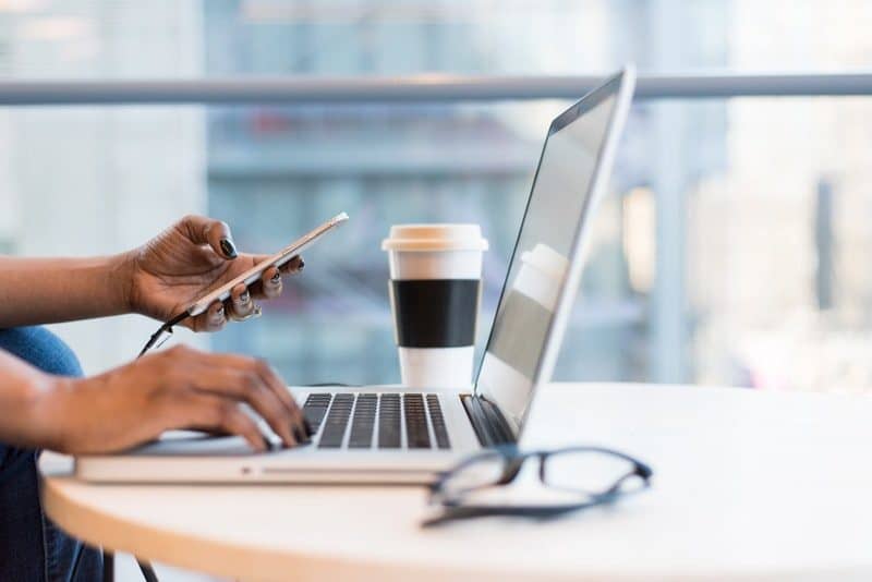 woman using a new macbook pro on a wooden table