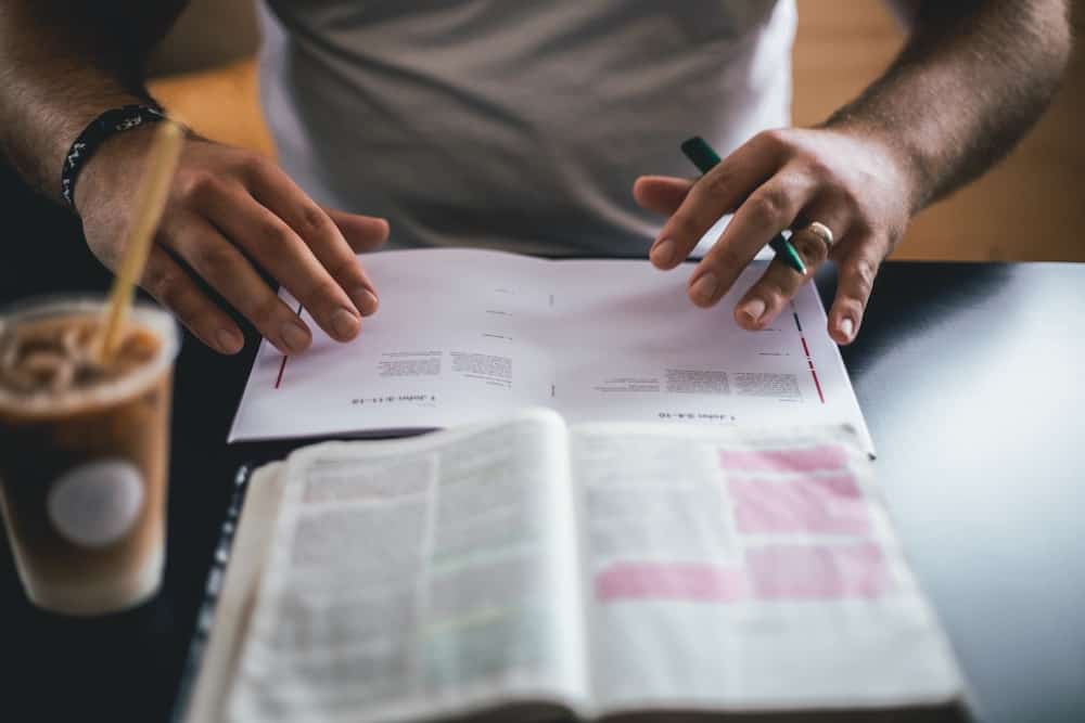 Man writing Ideas from a book to his notebook