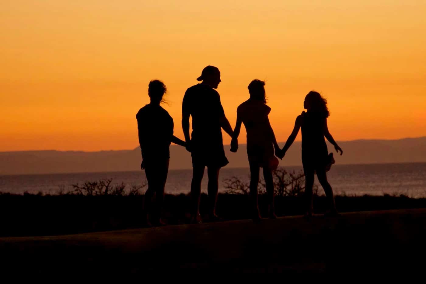 Family standing together while looking at the sunset