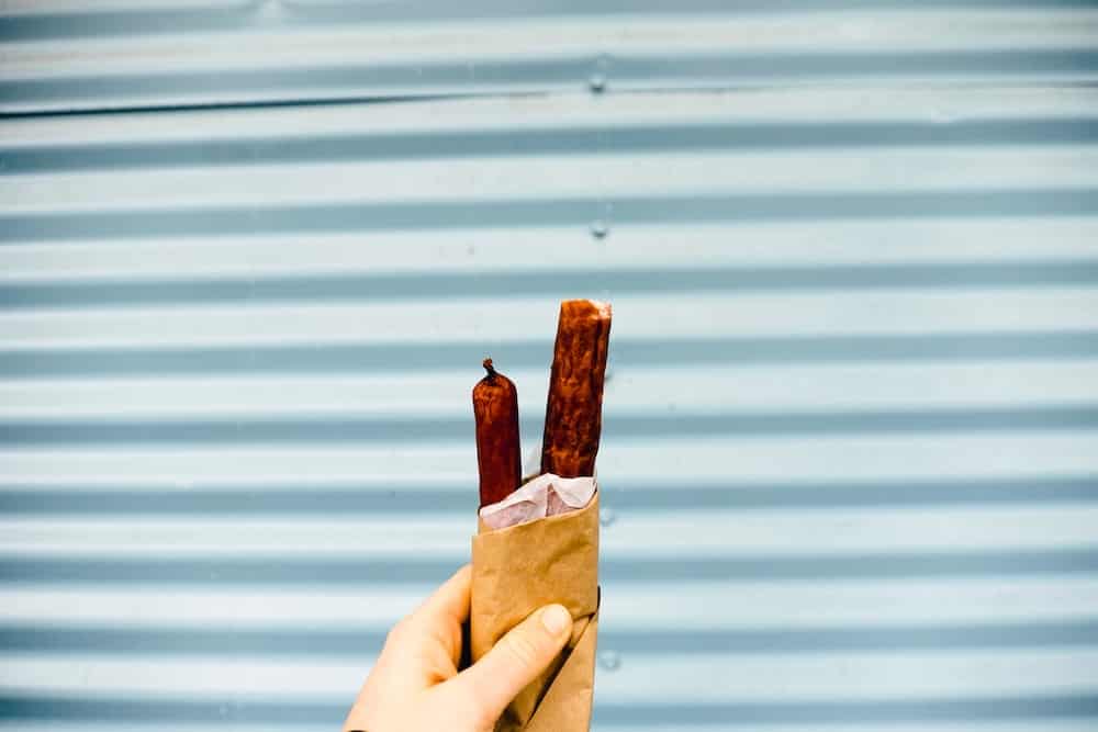 person carrying hotdog sandwich