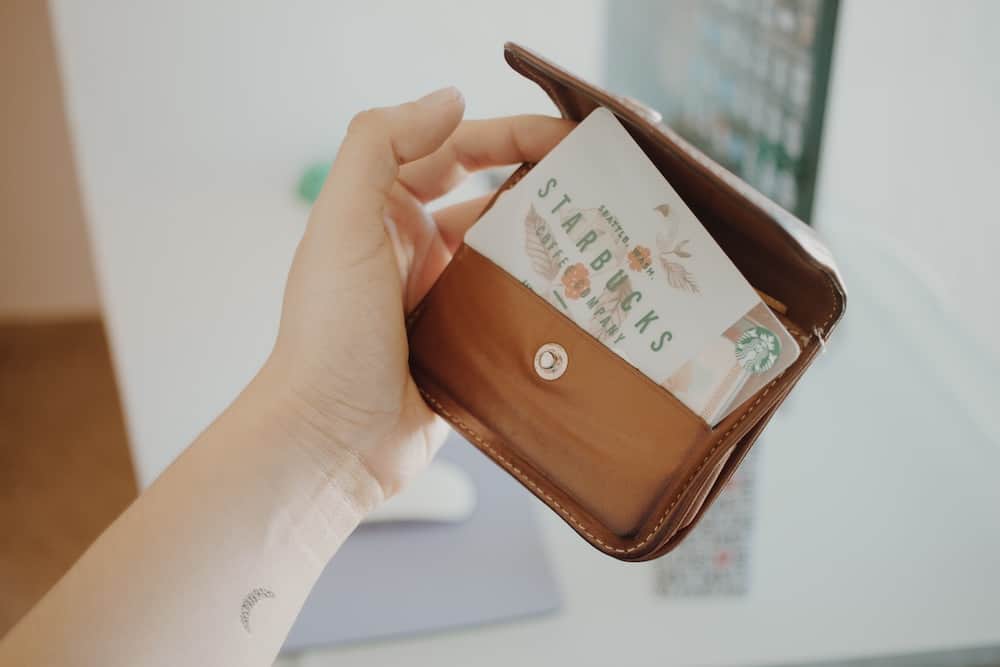 person holding brown leather coin purse