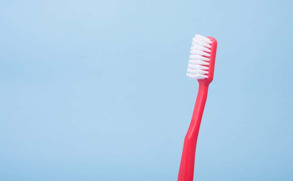 Red Toothbrush against blue background