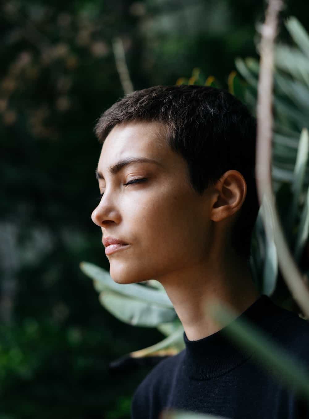 person standing in front of green plants