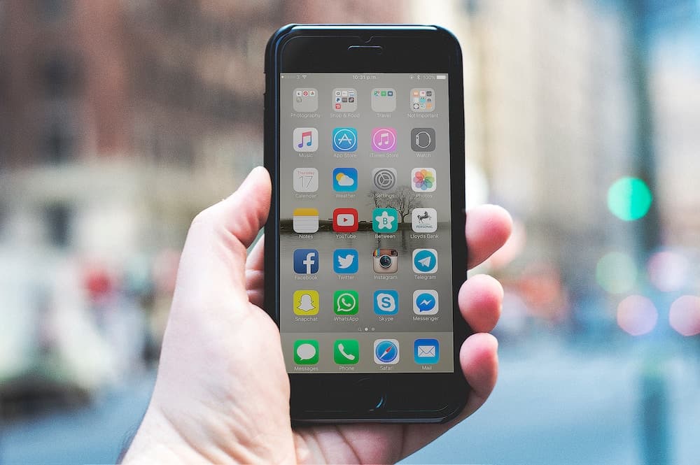 person holding a space gray iPhone 6 and black case