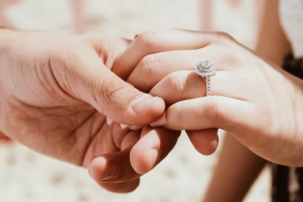 person holding another person hand with ring
