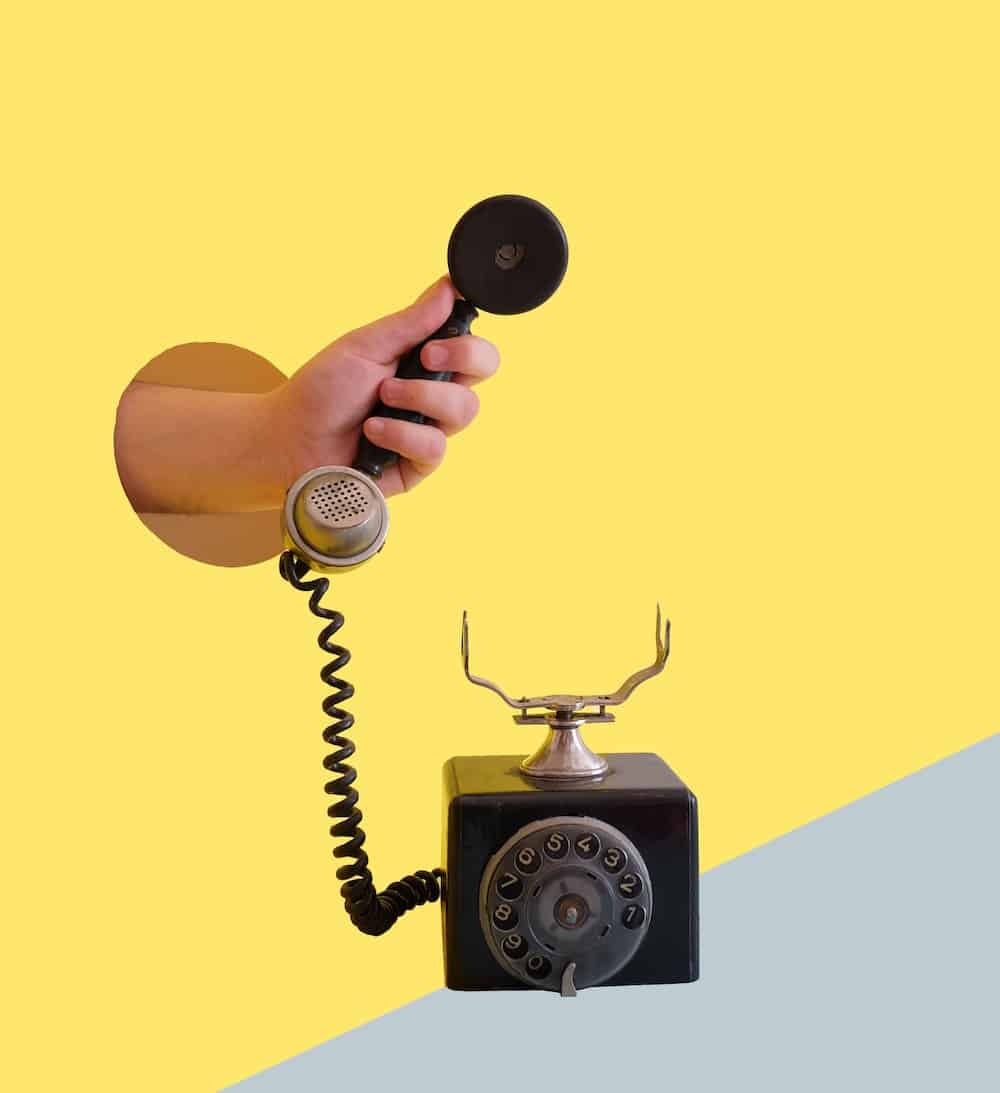 person holding black rotary telephone