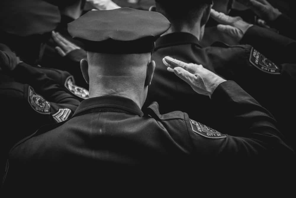 Black and White Photography of a Police Officer Giving Honor