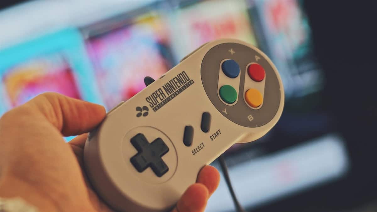 person-holding-white-snes-controller