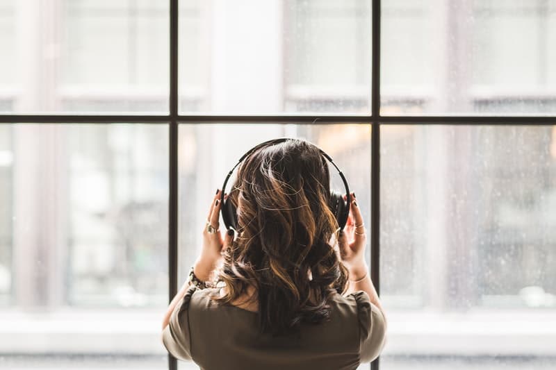 Beautiful Woman Looking out into the window while listening to music