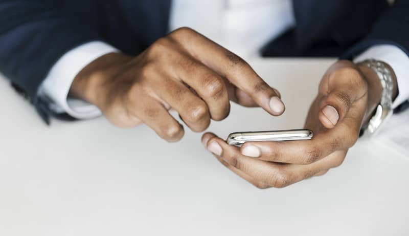 man in black suit holding smartphone