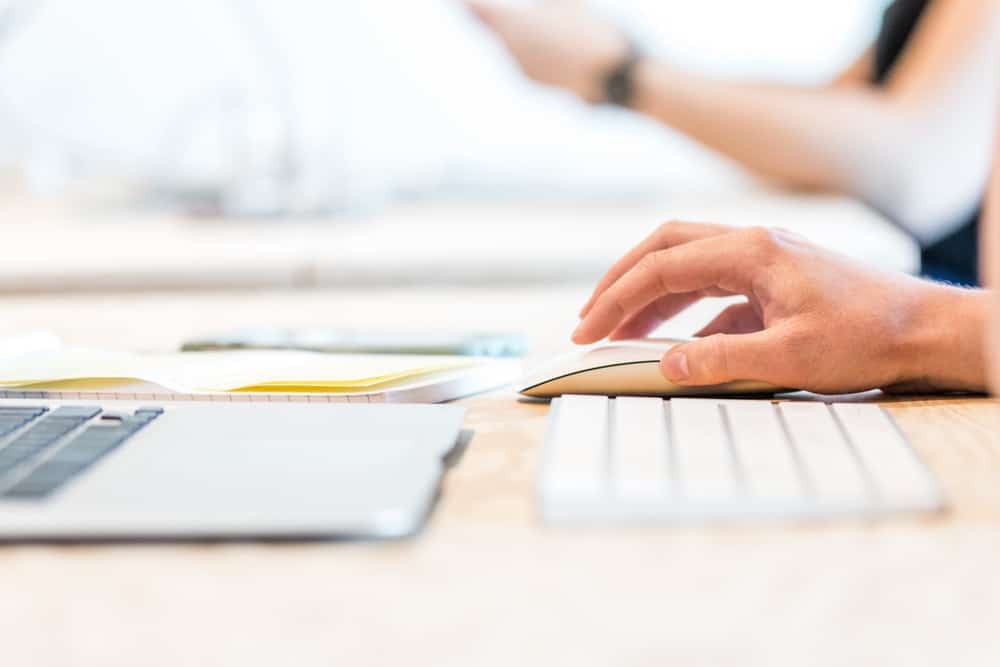 woman using white apple mouse