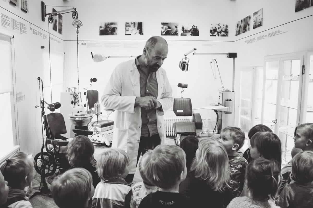 grayscale photo of man lecturing children