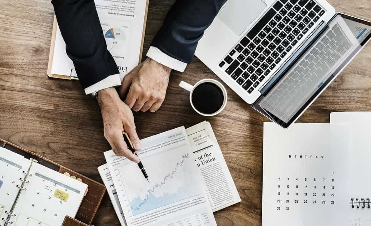 Photo of person holding a black pen and pointing to analytics