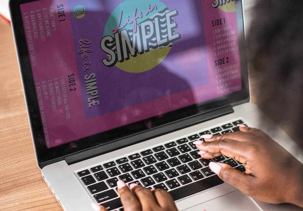 Woman creating a brochure on a macbook pro-min