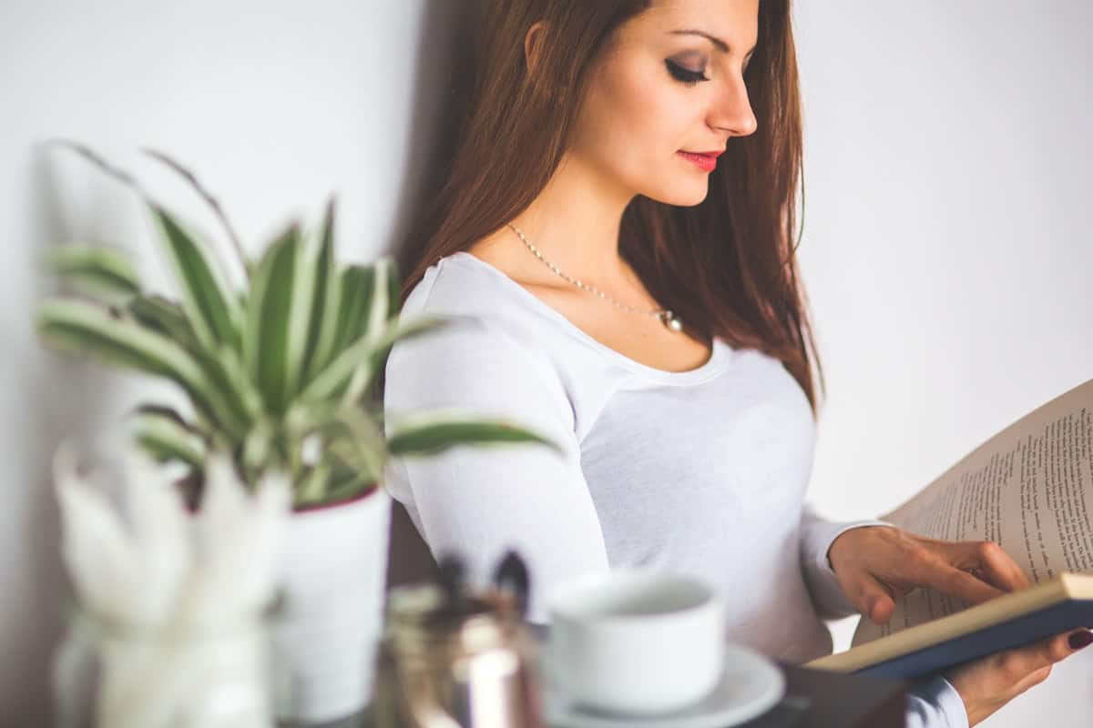 Young Woman Relaxing at Home and Reading a Book